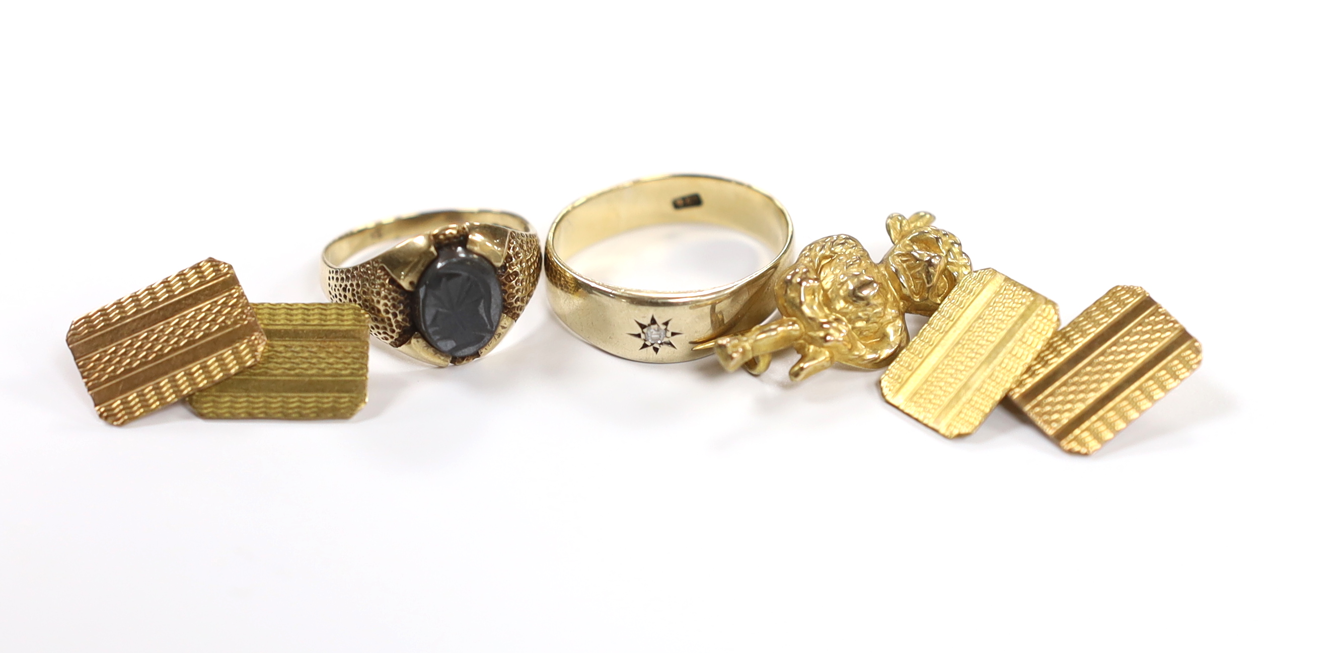 A pair of engine turned 9ct gold cufflinks, a 9ct 'Lincoln Imp' brooch and two 9ct rings including hematite signet ring, gross weight 13.6 grams.